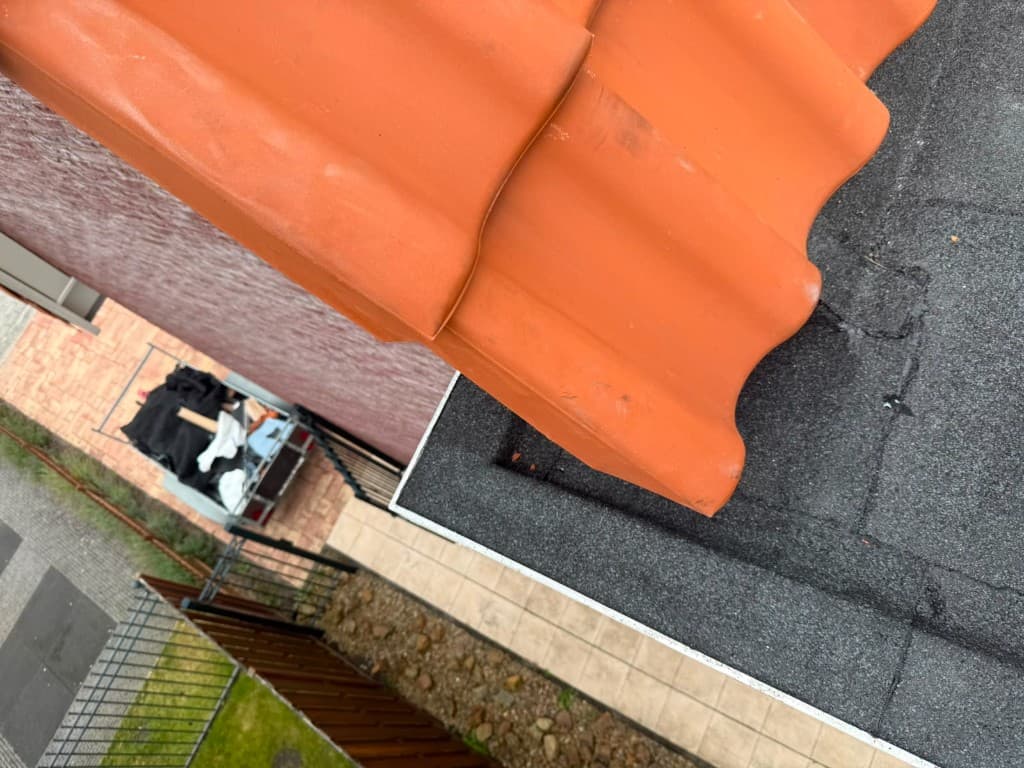 Detailopname van een dakpan en dakgoot bij een dakrand