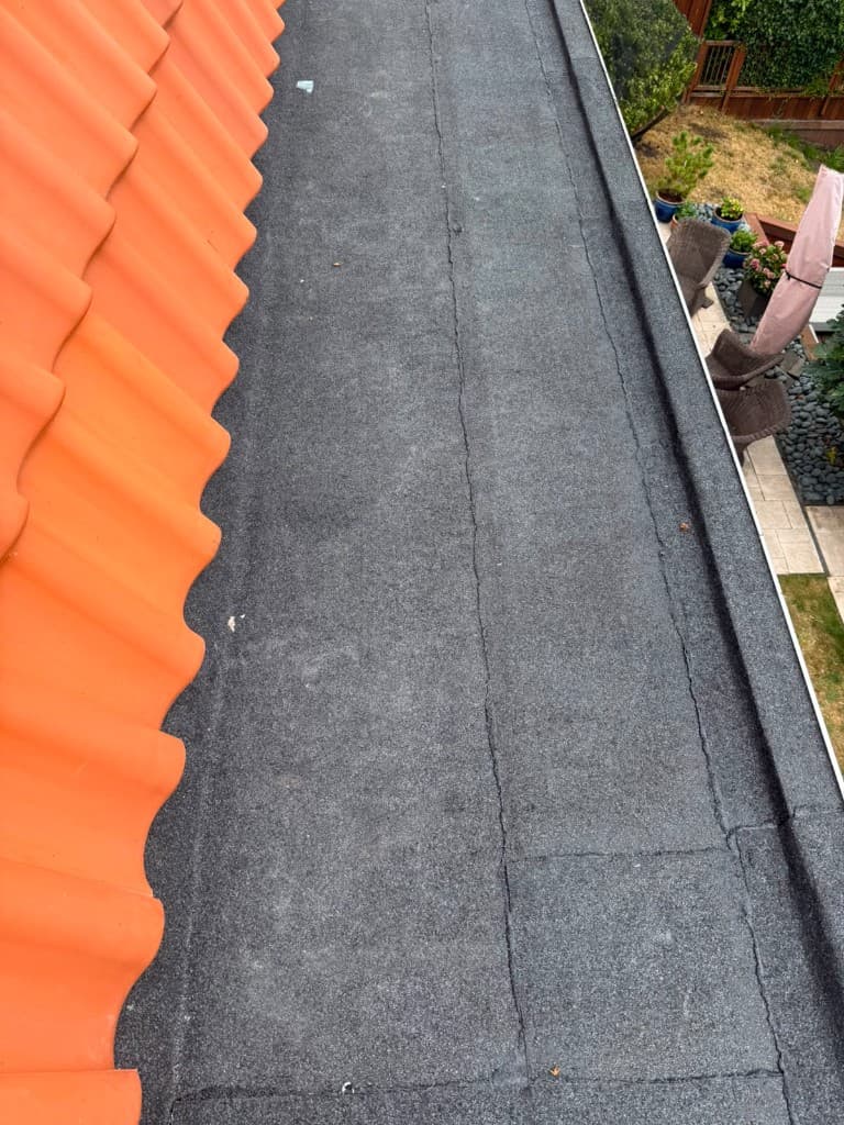 Dakgoot langs een pannendak, gereed voor onderhoud