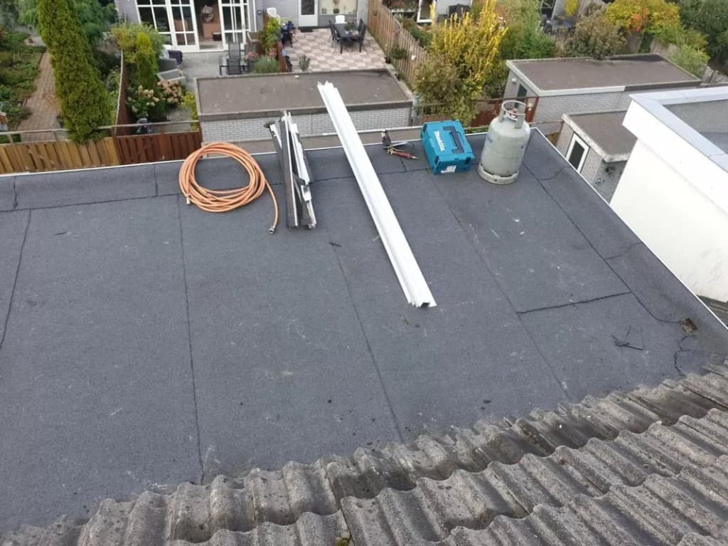 Plat dak met materiaal en gereedschap gereed voor werkzaamheden
