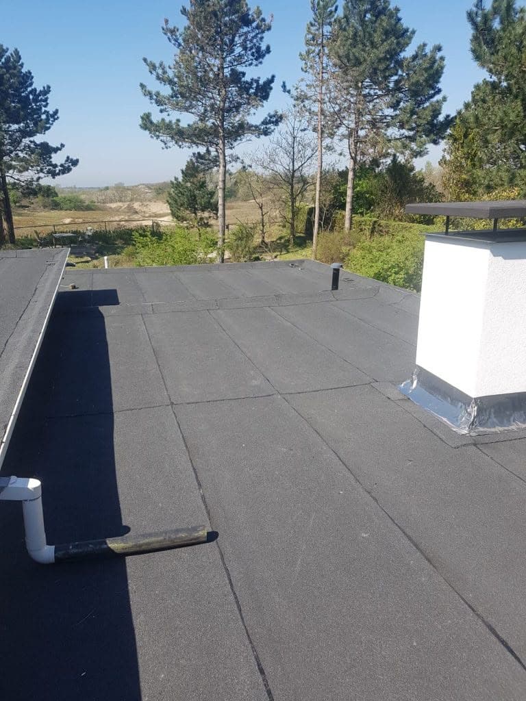Detail van loodwerk rond een schoorsteen op een plat dak